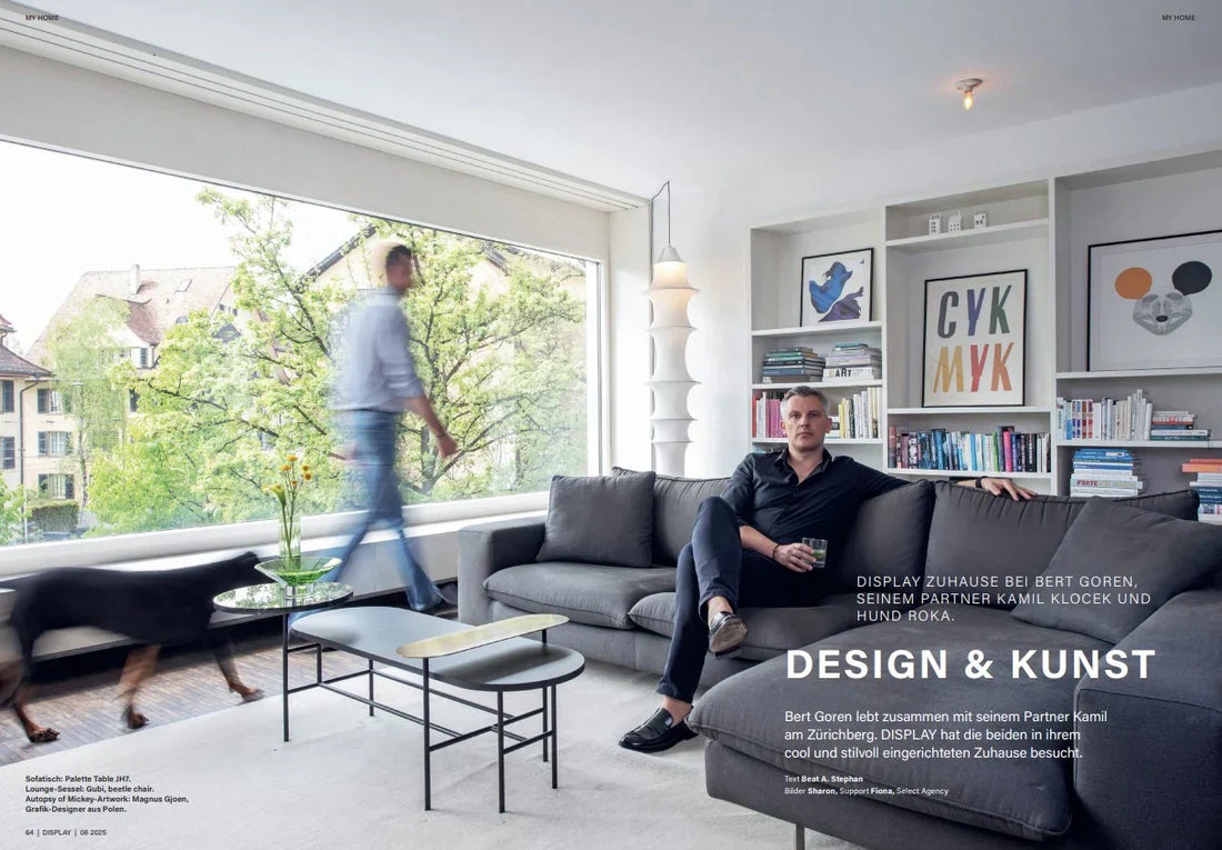 two people in a room, one with a dog and the other sitting on the couch