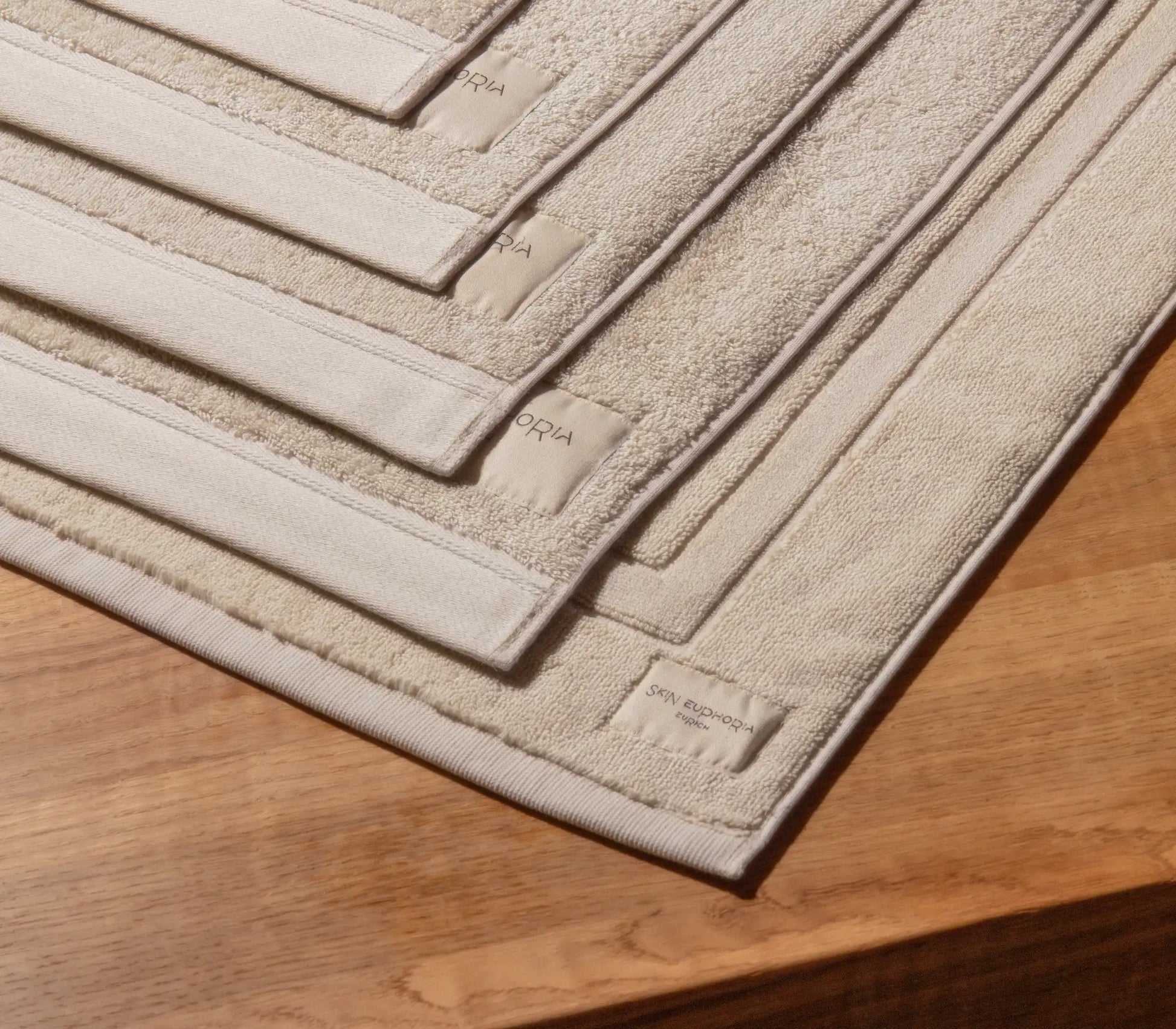 Beige bath mat with textured pattern on a wooden floor