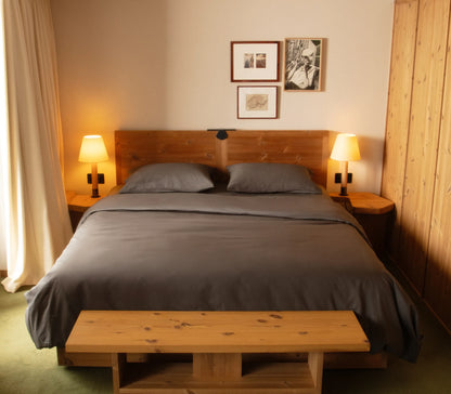 Bedroom with wooden bed, nightstands, and lamps.