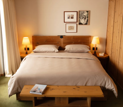 Bedroom with wooden bed, nightstands, and lamps.