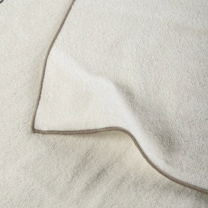 Close-up of a textured fabric with a brown border